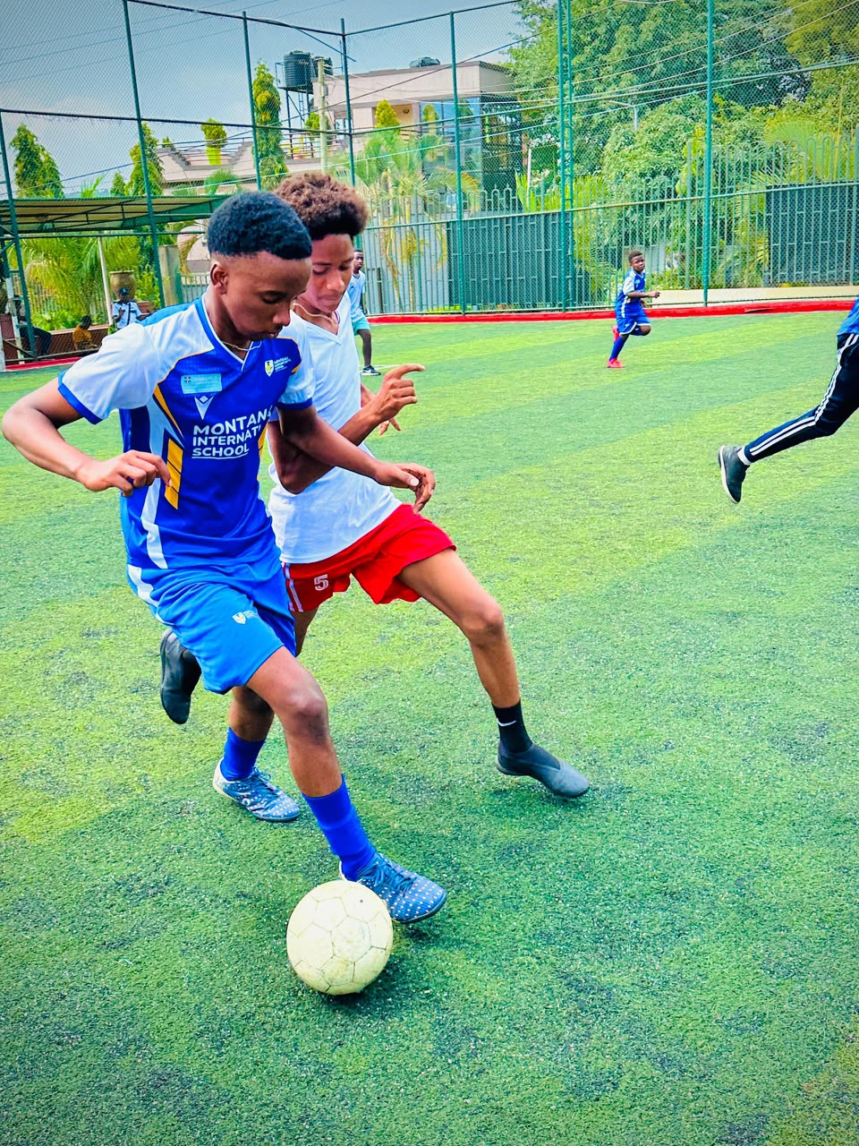 Montana International School students playing football on the turf pitch